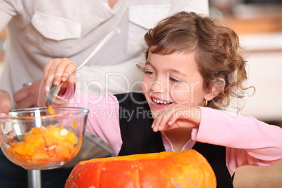 Little girl hollowing out a pumpkin