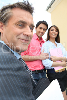 Estate-agent about to show couple round a property