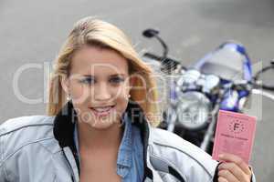 Teenage girl with motorbike and driving licence