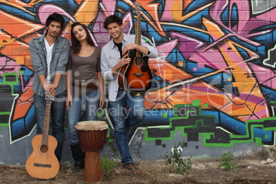 Rock band standing in front of graffiti