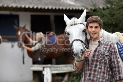 Man with horse in a stable