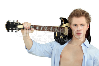 Serious young man with his guitar over his shoulder