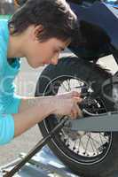 Teenage boy repairing motorcycle