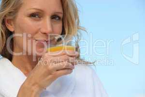 Woman drinking glass orange juice