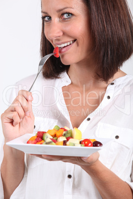 Woman eating fruit salad