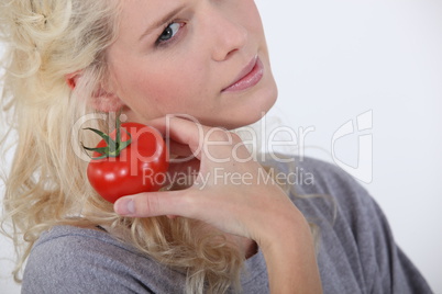 Blond woman holding tomato