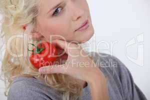 Blond woman holding tomato