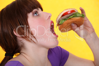 teenager eating hamburger