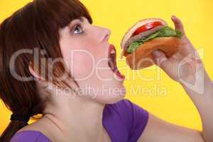 teenager eating hamburger