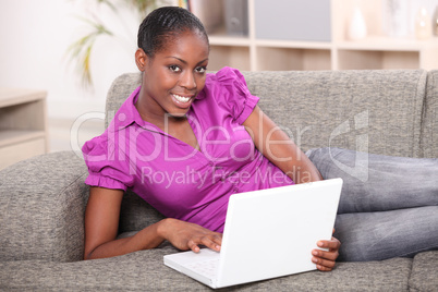 Young woman in a bright pink blouse using laptop computer