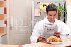 Man reading his newspaper over breakfast