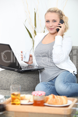 Woman eating breakfast in front of laptop