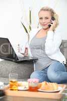 Woman eating breakfast in front of laptop