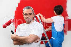 Couple painting wall red