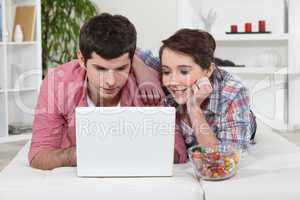 Young couple watching a film on their laptop
