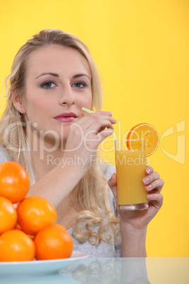 blonde woman drinking orange juice