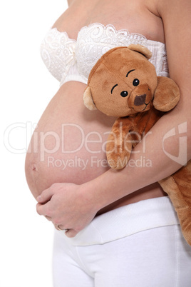 Pregnant woman holding a teddy bear