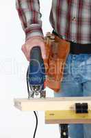 A cropped picture of a handyman using a jigsaw.