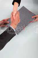 Business people shaking hands over a folder