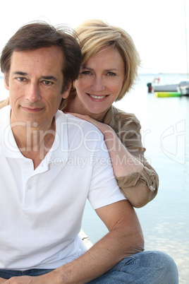 Couple posing by the water's edge