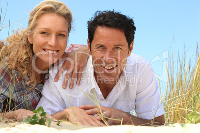 Couple lying on the sand.