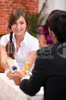 Man giving a woman a gift in a restaurant