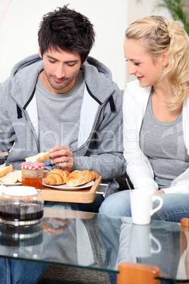 Couple eating breakfast on the sofa
