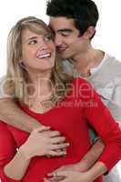 young happy couple embracing against studio background