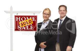 Businesswoman and Businessman Behind Real Estate Sign Isolated