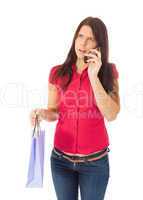 Das junge Mädchen mit der Einkaufstüte in der Hand telefoniert