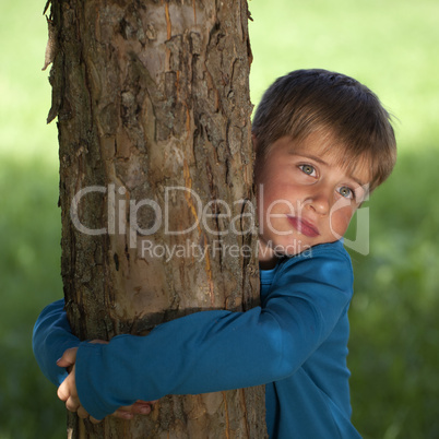 Junge umarmt einen Baum