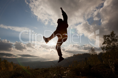 Happy man jumping at the sunset