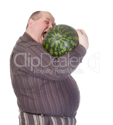 Obese man biting a watermelon