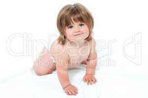Charming toddler in diapers trying to crawl