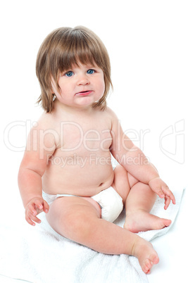Cute baby girl sitting up wearing a diaper