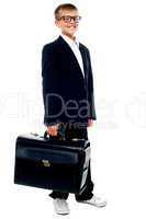 Full length portrait of cute boy carrying a briefcase