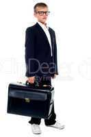 Serious young business boy holding office briefcase