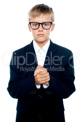 Pensive looking boy posing with hands clasped