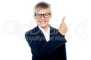 Adorable young boy in formals pointing away