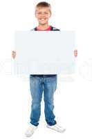 Full length portrait of boy holding blank whiteboard