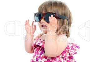 Adorable blonde baby queen adjusting her over sized shades