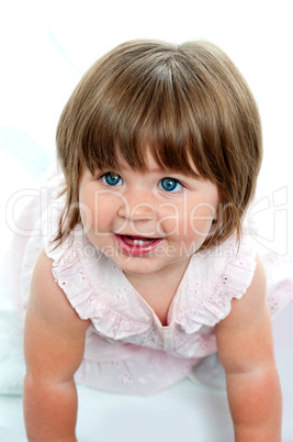 Baby girl with milk teeth crawling on the ground