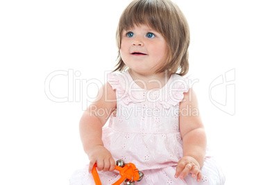 Adorable blonde infant playing with a rattle