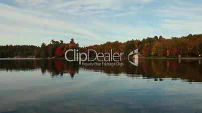 Calm lake and autumn forestAutumn trees reflecting on calm lake, Ontario, Canada