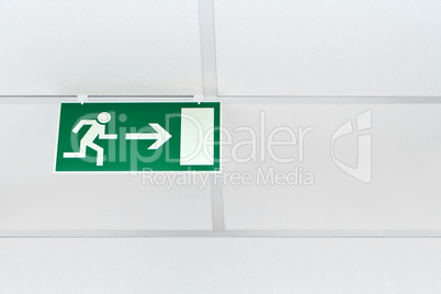 green emergency exit sign  on a white wall