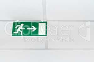 green emergency exit sign  on a white wall
