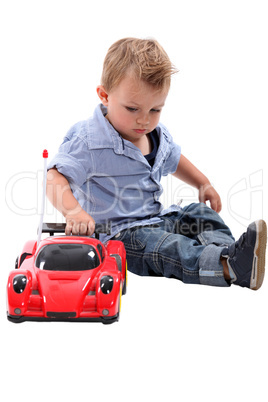 Young boy playing with a toy car