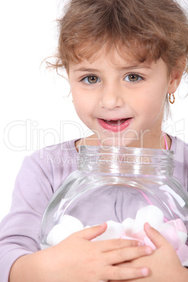 Little girl with marshmallows on white background
