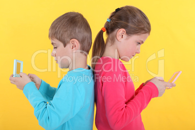 Brother and sister with hand-held video games