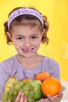 Little girl holding plate of fruit